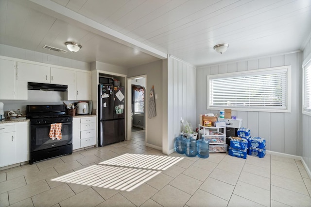 kitchen featuring light tile patterned floors, black appliances, and white cabinets