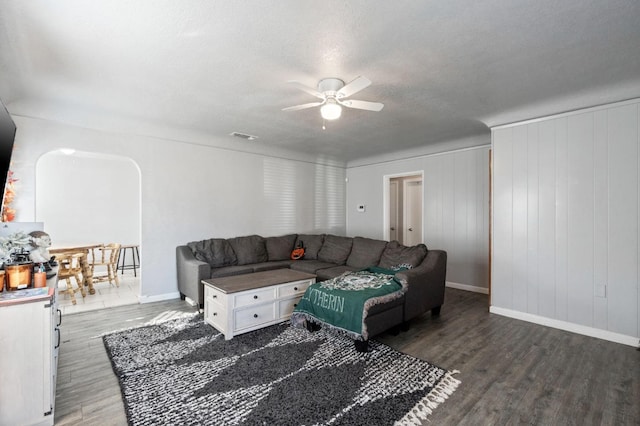 living room with ceiling fan, dark hardwood / wood-style floors, and a textured ceiling