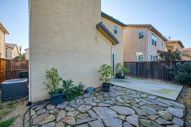 rear view of property featuring a patio and central air condition unit