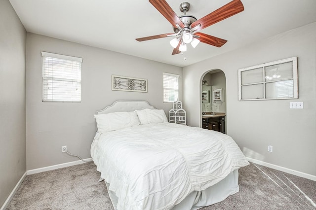 carpeted bedroom with connected bathroom and ceiling fan