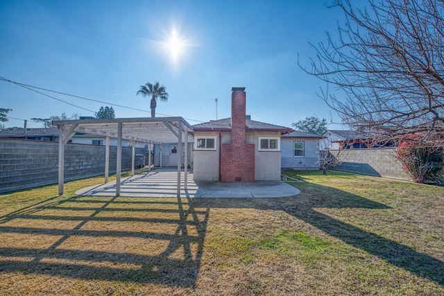 rear view of house featuring a pergola, a patio area, and a lawn