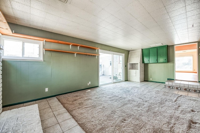 unfurnished living room featuring light tile patterned floors and a wealth of natural light