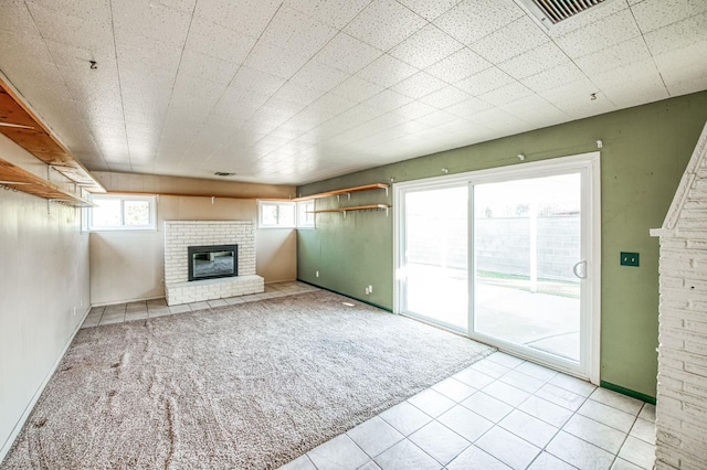 unfurnished living room featuring light colored carpet and a brick fireplace