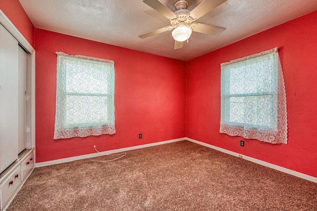 unfurnished room featuring ceiling fan, carpet flooring, and a textured ceiling