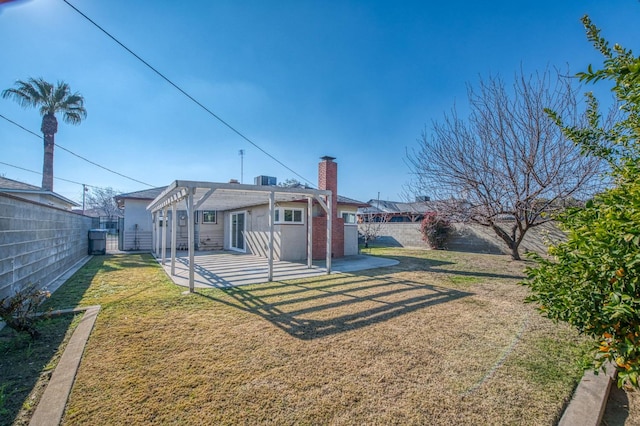 rear view of house with a patio, a pergola, and a lawn