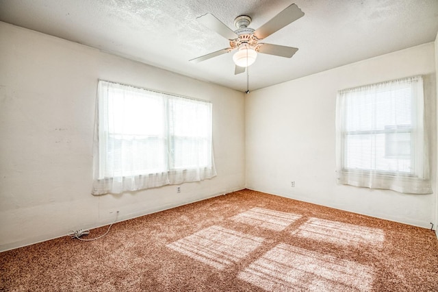 carpeted spare room with ceiling fan and a textured ceiling