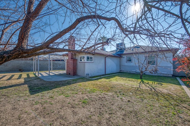 rear view of property featuring a lawn and a patio