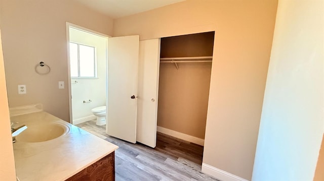 1859 S Karen Ave, Fresno, CA 93727 - bathroom featuring vanity, toilet, wood finished floors, baseboards, and a spacious closet