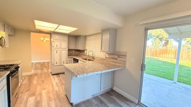 1859 S Karen Ave, Fresno, CA 93727 - kitchen with a sink, stainless steel appliances, light wood-type flooring, a peninsula, and light stone counters