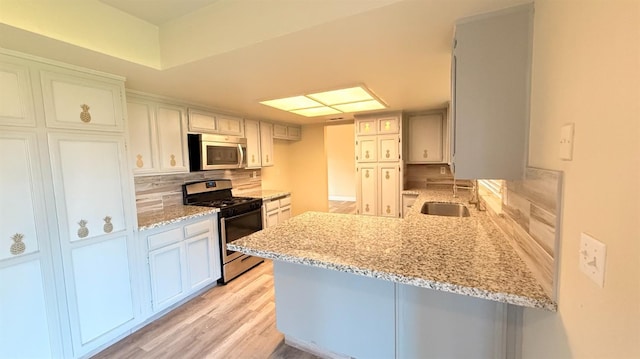 1859 S Karen Ave, Fresno, CA 93727 - kitchen with appliances with stainless steel finishes, a sink, a peninsula, decorative backsplash, and light stone counters