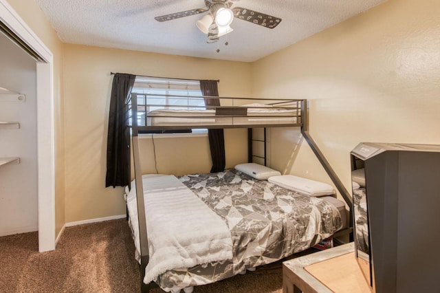 bedroom featuring dark carpet, a textured ceiling, and ceiling fan