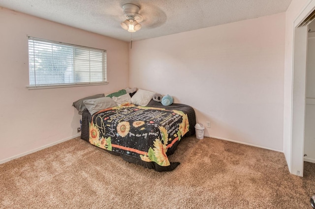 carpeted bedroom featuring a textured ceiling and ceiling fan