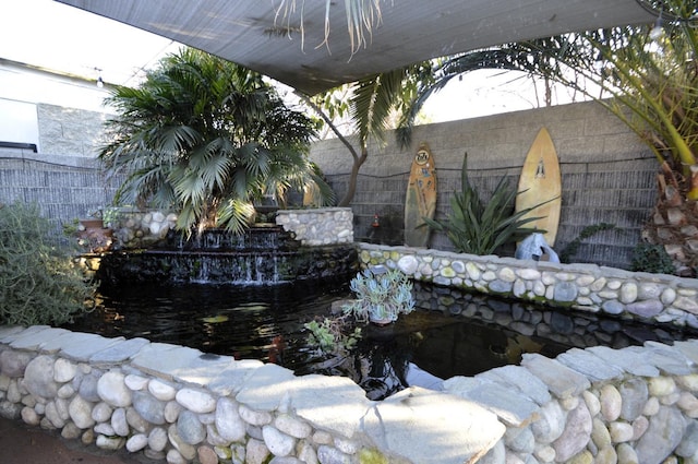 details featuring a small pond and fence