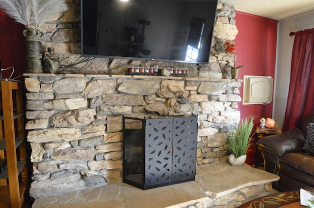 details featuring a stone fireplace and a textured ceiling