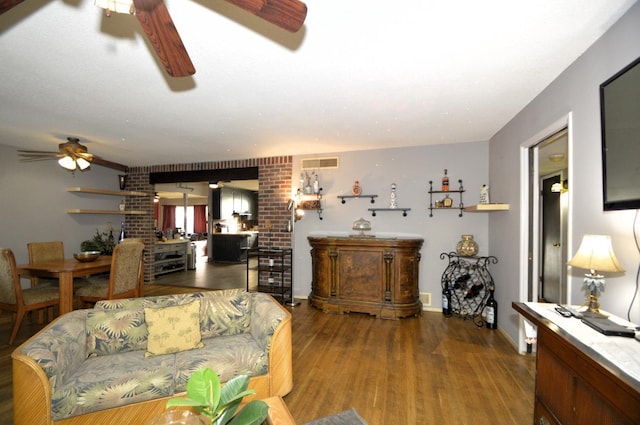 living area with visible vents, ceiling fan, and wood finished floors