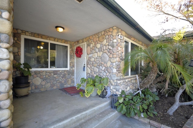 property entrance featuring stone siding