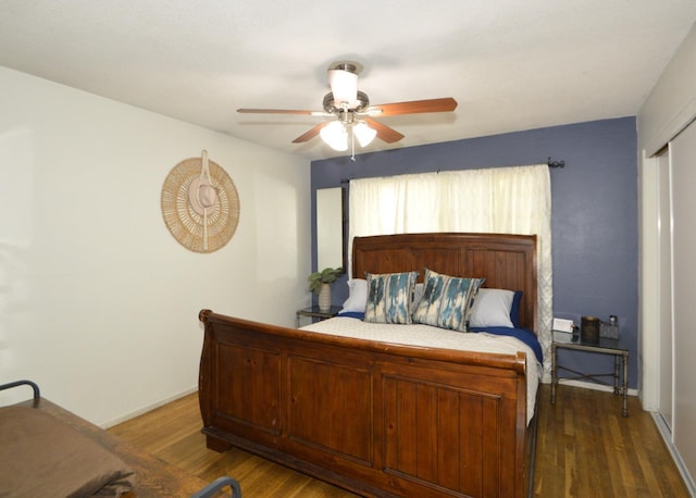 bedroom featuring ceiling fan, baseboards, and wood finished floors