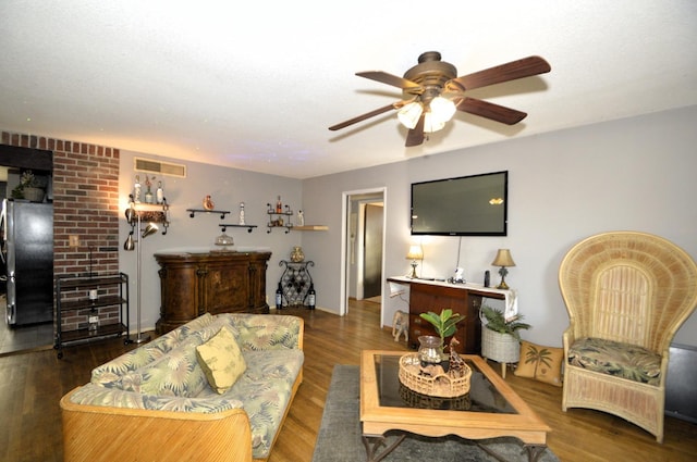 living area with visible vents, ceiling fan, and wood finished floors