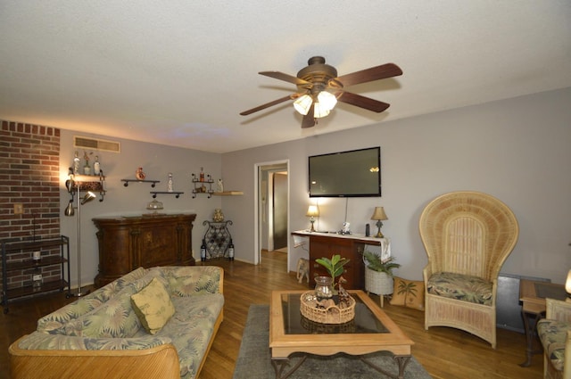 living area featuring ceiling fan, visible vents, and wood finished floors