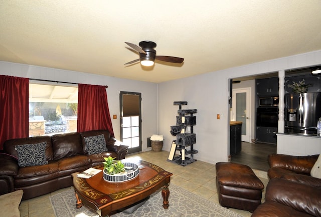 tiled living area featuring a ceiling fan and a healthy amount of sunlight