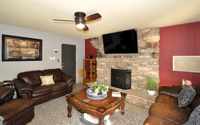 tiled living area featuring ceiling fan and a fireplace