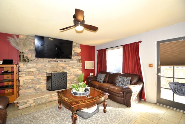 living area with a fireplace and a ceiling fan