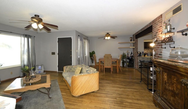 living room with ceiling fan, baseboards, and wood finished floors