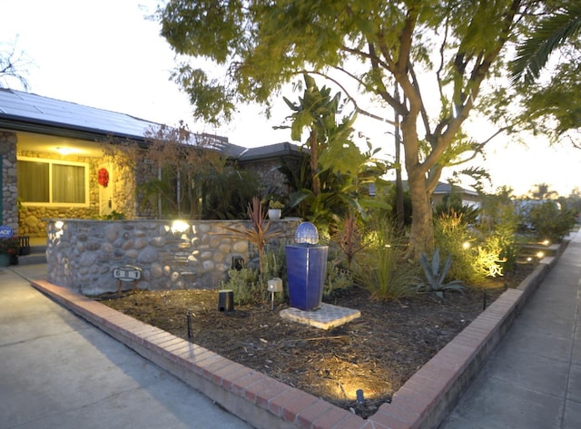 exterior space with stone siding and solar panels