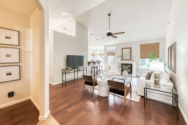 living room with ceiling fan, lofted ceiling, and dark hardwood / wood-style flooring