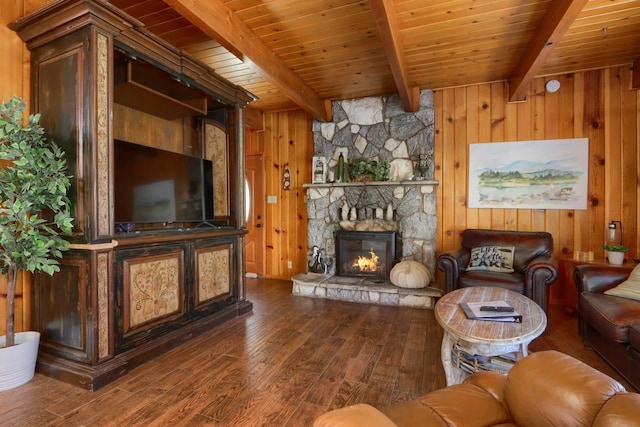 unfurnished living room featuring a stone fireplace, wood walls, beamed ceiling, hardwood / wood-style flooring, and wooden ceiling