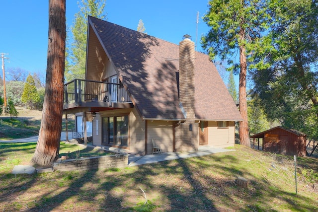 back of house featuring a storage unit, a lawn, and a garage