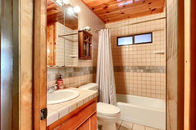 full bathroom featuring tile walls, vanity, toilet, tile patterned floors, and shower / bath combo with shower curtain