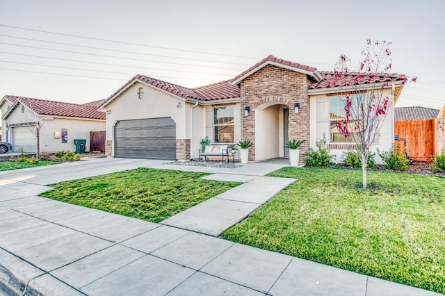 mediterranean / spanish home with a garage and a front yard