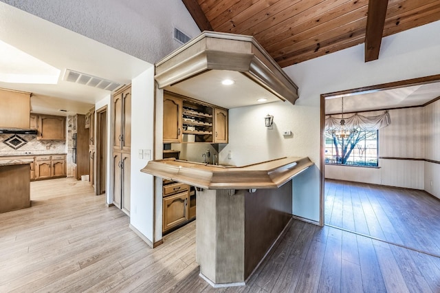 kitchen featuring hanging light fixtures, wood ceiling, light hardwood / wood-style flooring, and a kitchen breakfast bar