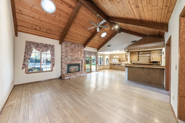 unfurnished living room featuring beamed ceiling, a brick fireplace, wooden ceiling, and light wood-type flooring