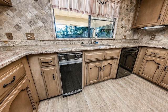 kitchen featuring sink, light hardwood / wood-style floors, black dishwasher, and light stone countertops