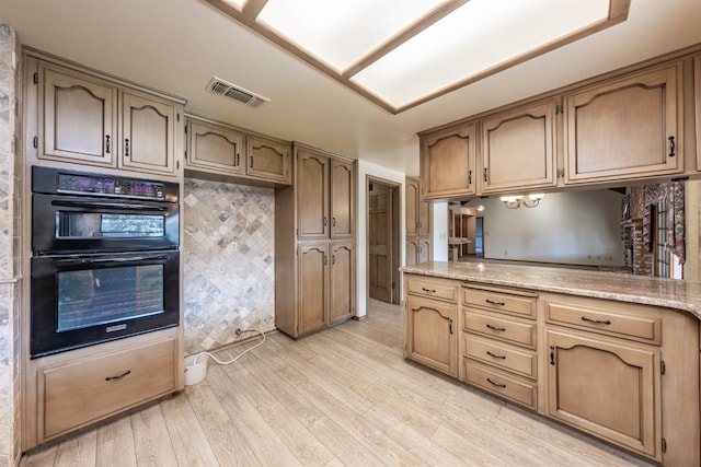 kitchen featuring double oven and light wood-type flooring