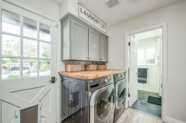 laundry room with cabinets, independent washer and dryer, and light hardwood / wood-style floors