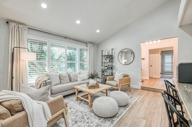 living room with vaulted ceiling and light hardwood / wood-style flooring