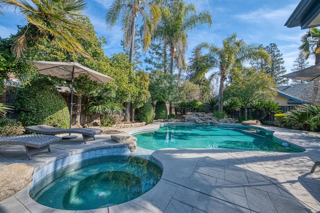 view of swimming pool with an in ground hot tub and a patio