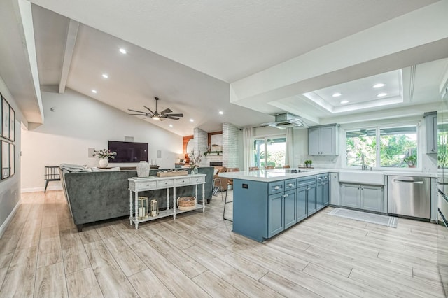 kitchen featuring vaulted ceiling, a fireplace, dishwasher, sink, and kitchen peninsula