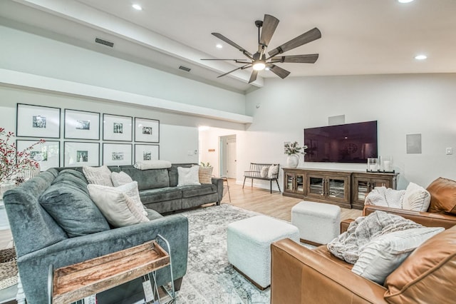 living room with high vaulted ceiling, ceiling fan, and light hardwood / wood-style flooring