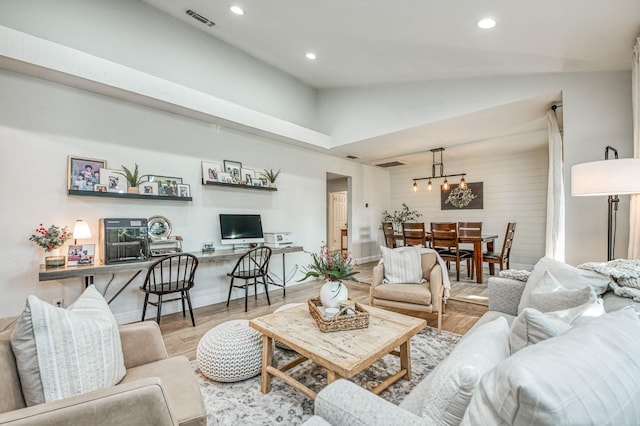 living room featuring high vaulted ceiling and light wood-type flooring