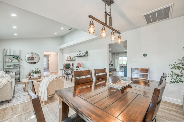 dining area featuring lofted ceiling and light hardwood / wood-style floors