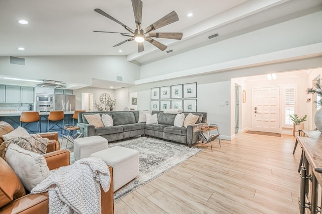 living room featuring ceiling fan, high vaulted ceiling, and light hardwood / wood-style floors