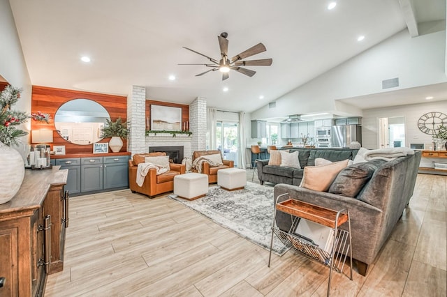 living room with high vaulted ceiling, a fireplace, and ceiling fan