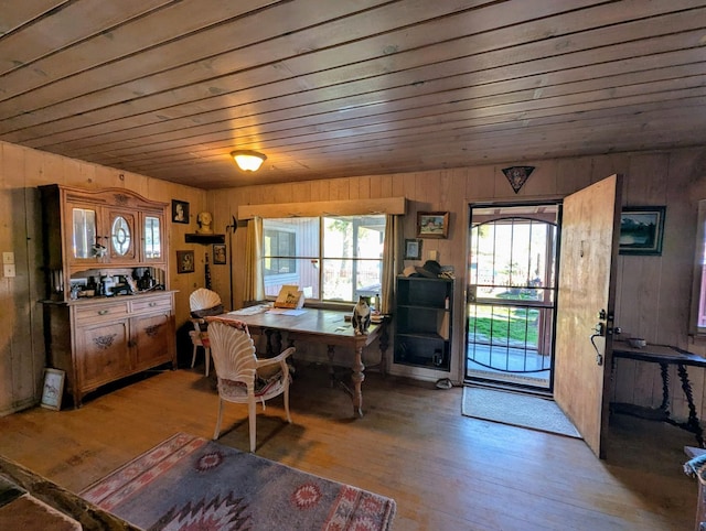 dining room featuring wood ceiling, light hardwood / wood-style floors, and wood walls