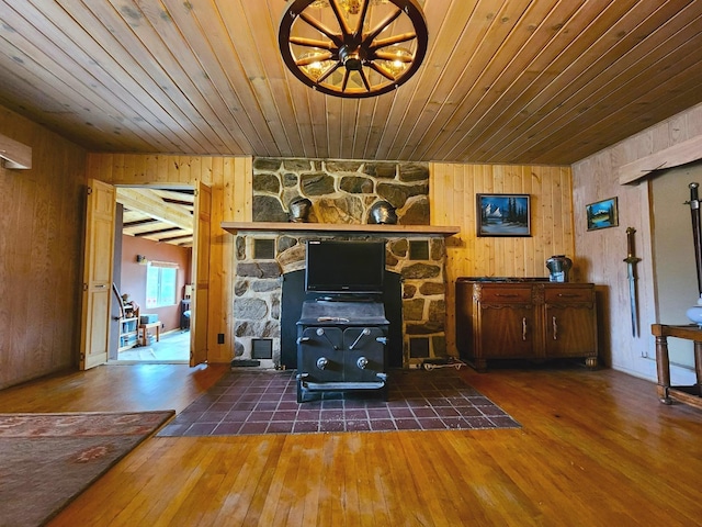 living room with dark hardwood / wood-style floors, a wood stove, wood ceiling, and wood walls