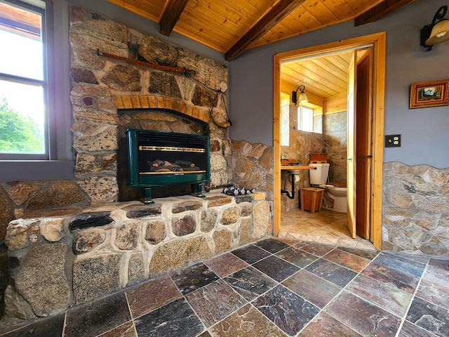 room details featuring beam ceiling, a stone fireplace, and wood ceiling