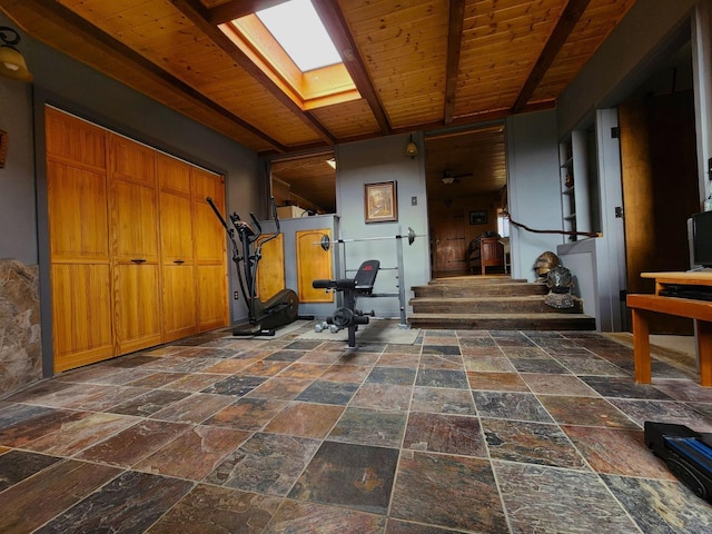 exercise area with a skylight and wooden ceiling